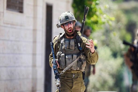 جندي إسرائيلي يلقي قنبلة على مكتب وزارة الدفاع بتل أبيب